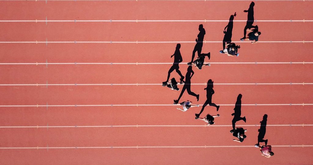 Photo de coureurs sur une piste d'athlétisme pour illustrer le fait que le no code permet de réduire le temps de développement des applications mobiles et métiers.